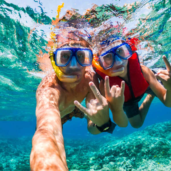 Mann und Frau machen Selfies unter Wasser beim schnorcheln in Marsa Alam.