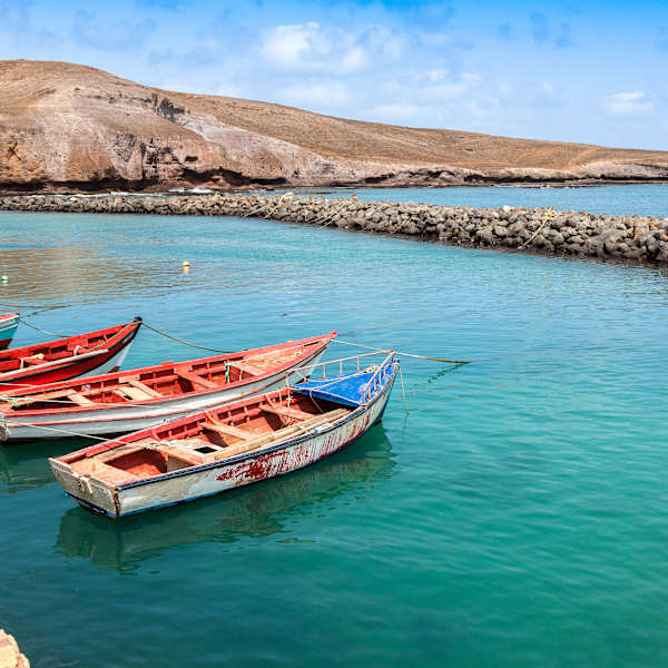 Ein Hafen mit roten Booten und türkisem Wasser