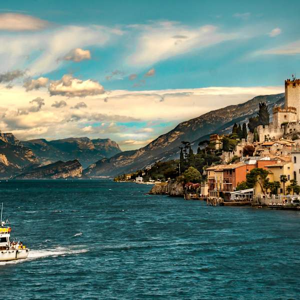 Landschaft des Gardasees mit Boot und Tignale im Hintergrund