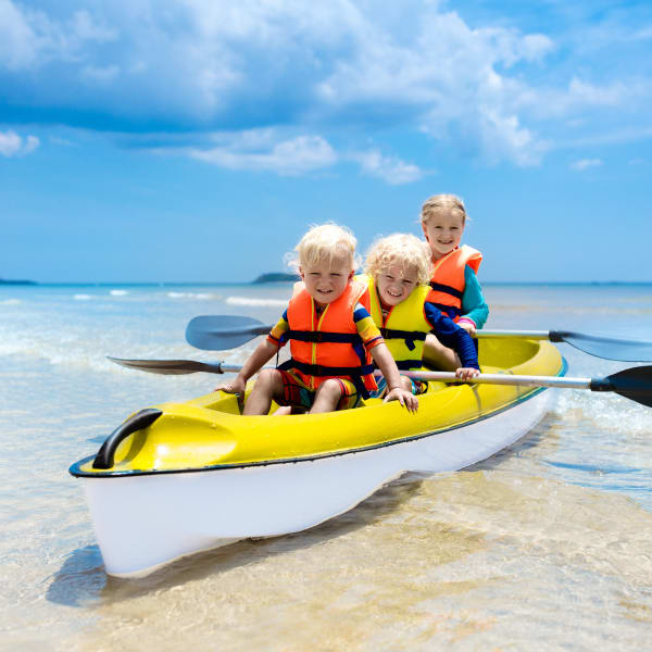Kinder fahren Kanu im Meer